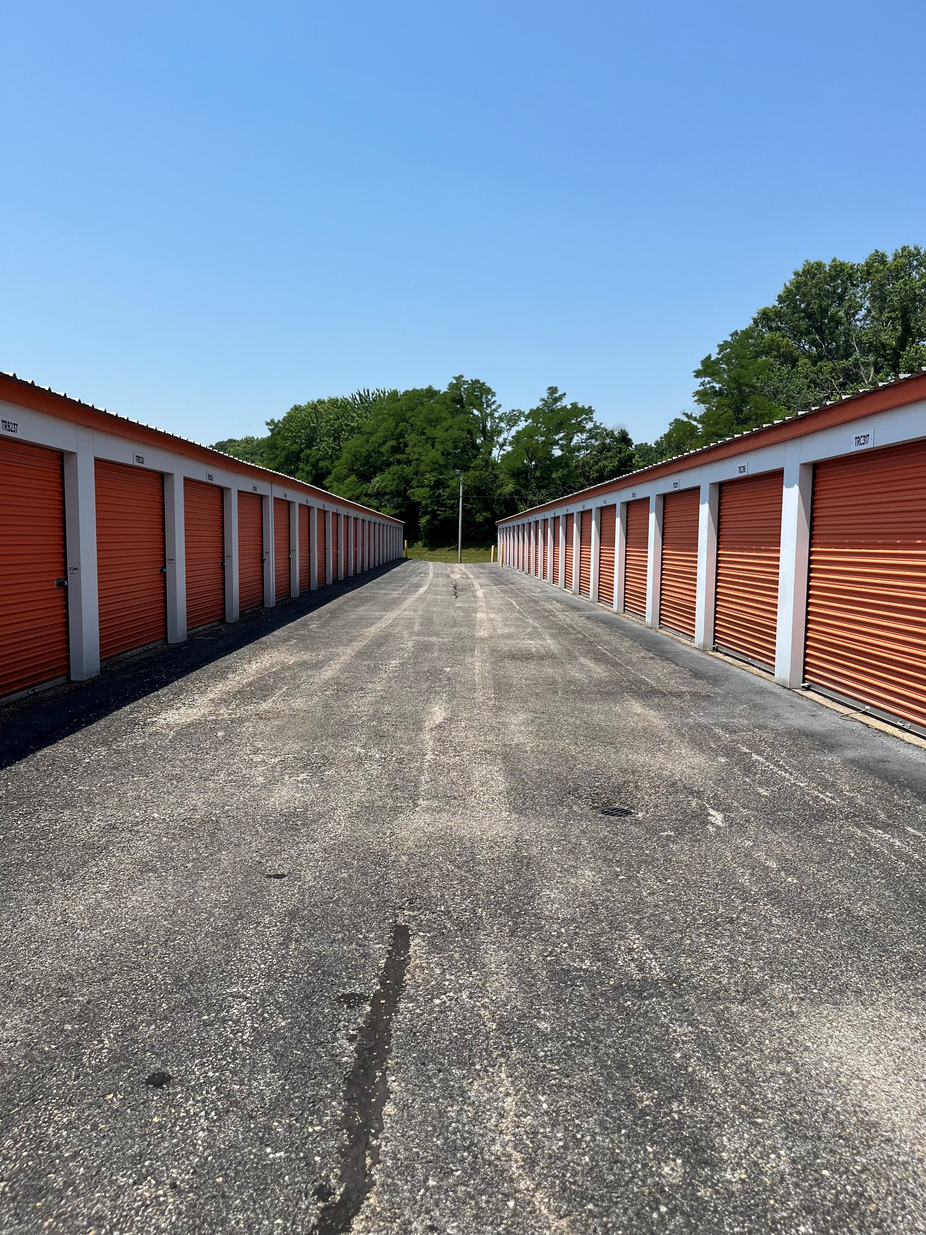 Truman Rd, Jasper, IN: Drive-up storage units with white doors, set along clean, paved, and wide driveways for easy access.